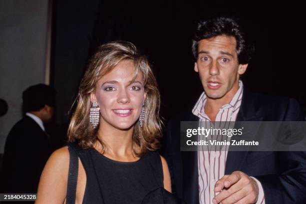 American actress Hilary Edson, wearing a black crew neck outfit, with large drop earrings, and American actor Michael Spound, who wears a black...