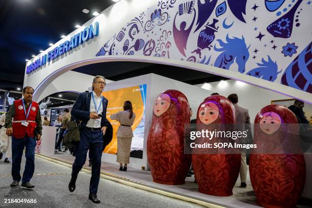 Participants walk by Russian Federation Pavilion during the United Nations Climate Change Conference COP29, an event held by United Nations Framework...