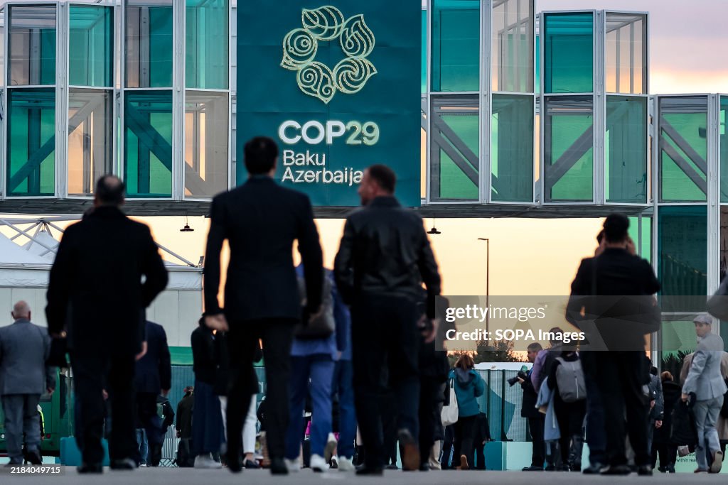Participants walk in front of the main entrance during the...