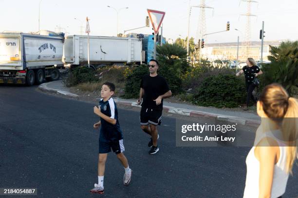 People run for a cover to a bomb shelter as sirens warning for a rocket attack are heard on November 14, 2024 in Kiryat Bialik, Israel. Hezbollah...