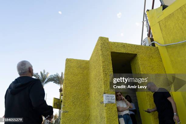 Man looks at interception of rockets by the Israeli iron dome near a bomb shelter after sirens warning for rocket attack are heard on November 14,...