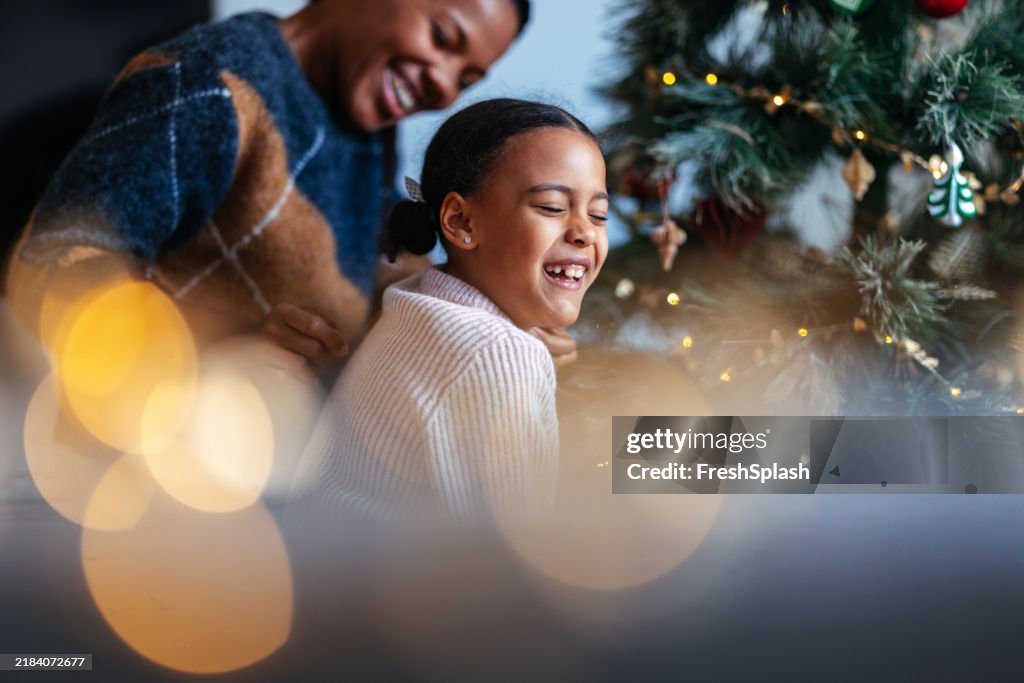 Mother and Daughter Laughing by Festive Christmas Tree