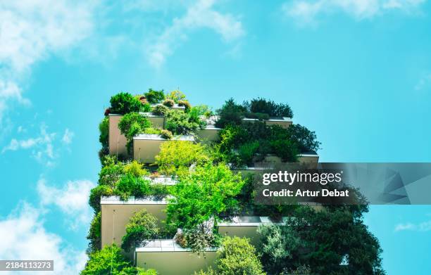 green residential tower covered with a urban garden taken from low angle - bâtiment écologique photos et images de collection