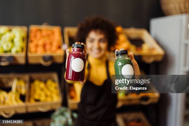 woman holding bottles of healthy handmade juice - bar à jus de fruits photos et images de collection