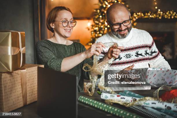 coppia matura che avvolge i regali di natale - avvolto foto e immagini stock