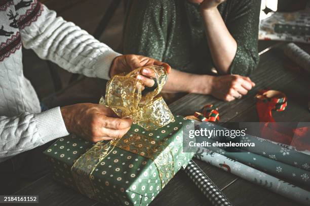 mature couple wrapping christmas presents - wrapping stock pictures, royalty-free photos & images
