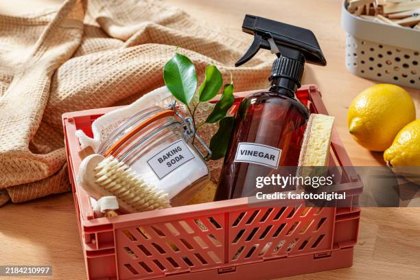 home cleaning with natural and eco friendly products: baking soda, white vinegar, lemon, scrubbing brush and cleaning sponge - azijn stockfoto's en -beelden