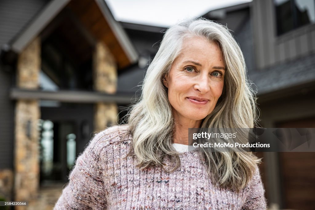Portrait of senior woman in front of beautiful vacation home