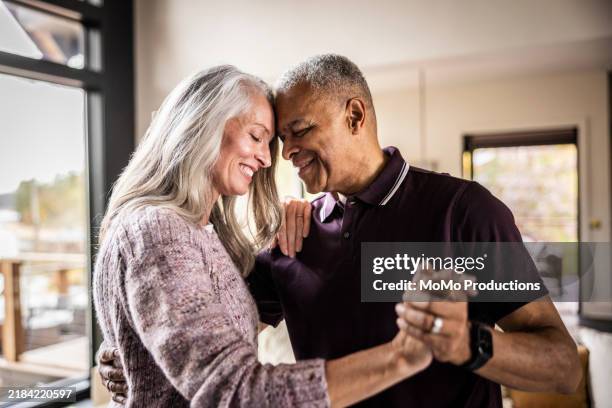 senior couple dancing in living room of home - suggestive stock pictures, royalty-free photos & images