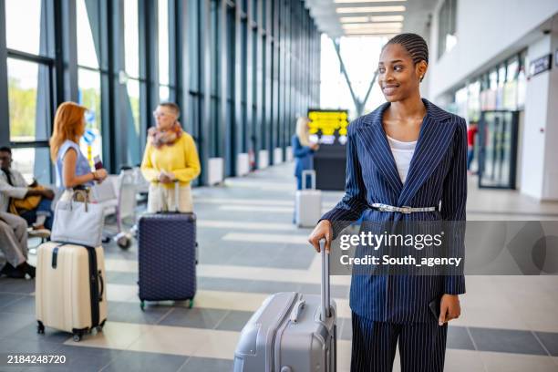businesswoman with suitcase looks forward in airport hall. - posto de controlo de segurança imagens e fotografias de stock