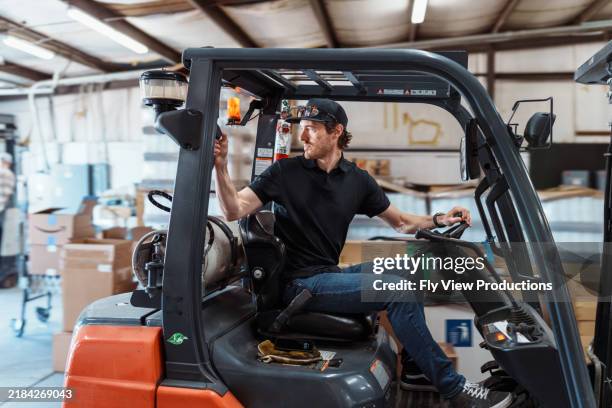 hombre operando carretilla elevadora en almacén - carretilla elevadora fotografías e imágenes de stock