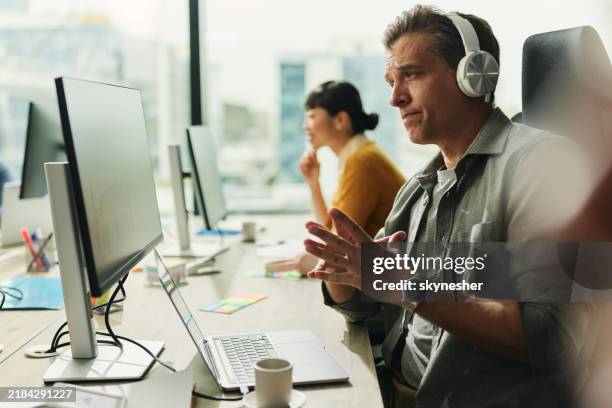 male programmer having a video call over pc in the office. - programmer computer stock pictures, royalty-free photos & images