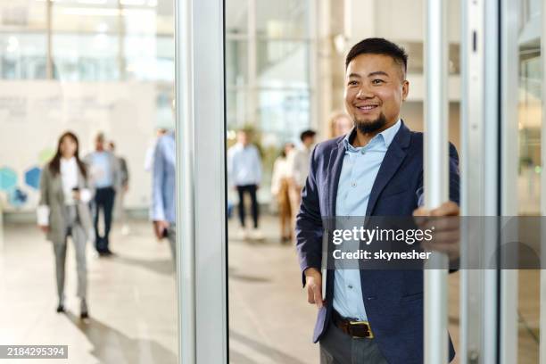 happy chinese businessman exiting the office building. - entered stock pictures, royalty-free photos & images