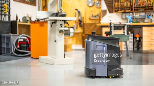 autonomous cleaning robot active in workshop - stofzuiger stockfoto's en -beelden
