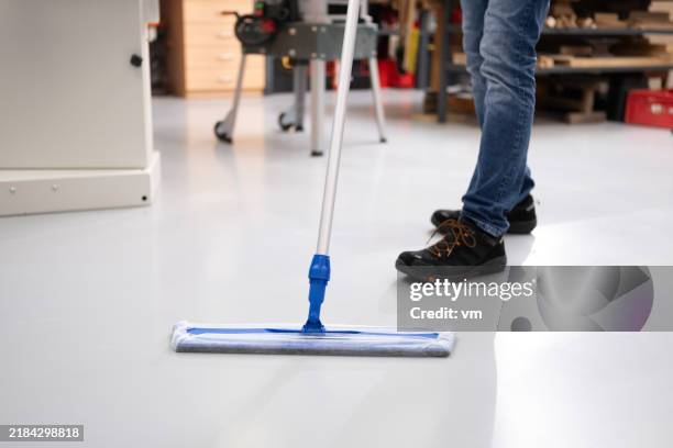 anonymous worker cleans workshop floor - vegen stockfoto's en -beelden