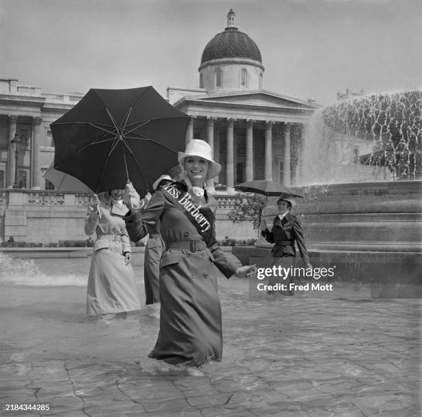 'Miss Burberry' 1970, Brenda Capewell, poses in one of the Trafalgar Square fountains with three other models in Burberry rainwear fashions, London,...