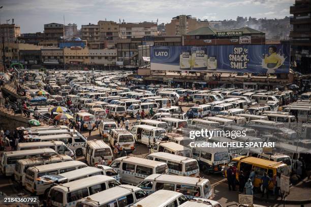 People navigate through hundreds of buses parked at Kisenyi Bus Terminal in Kampala on November 15, 2024.