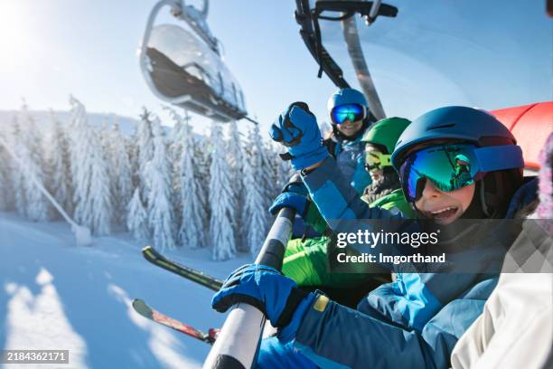 family enjoying ski-lift ride together - ski goggles stock pictures, royalty-free photos & images