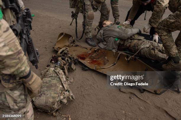Fallen member of the Ukrainian Army is carried out of an armoured vehicle at a casualties collection point on November 11 northwest of Toretsk,...
