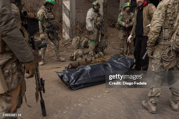 Fallen member of the Ukrainian Army is carried out of an armoured vehicle at a casualties collection point on November 11 northwest of Toretsk,...
