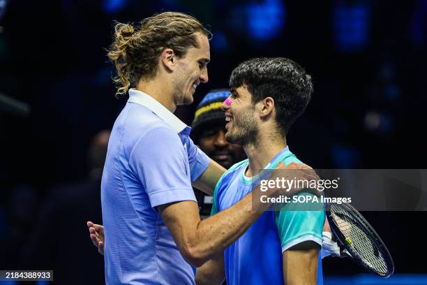 Alexander Zverev of Germany hugs Carlos Alcaraz of Spain at the end of the Men's Singles Round match during day six of the Nitto ATP finals 2024 at...