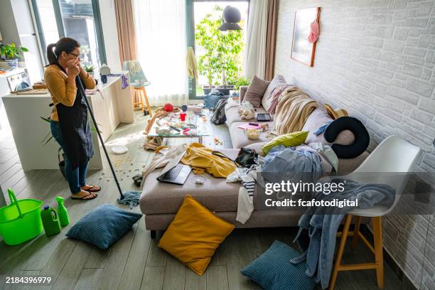 upset housewife contempling her messy and dirty home interior - amontoar imagens e fotografias de stock
