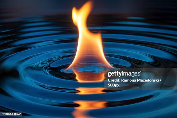 a vibrant and dynamic scene where a fiery,orange flame rises from a central point - candle flame stock pictures, royalty-free photos & images