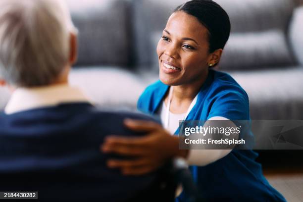 compassionate nurse providing care to an elderly patient at home - gerontology stock pictures, royalty-free photos & images