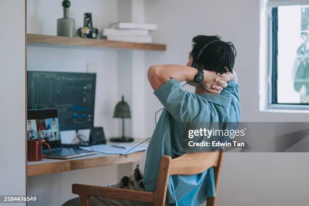 hombre chino asiático manos detrás de la espalda mirando la videollamada del monitor de la computadora en casa - oficio financiero fotografías e imágenes de stock