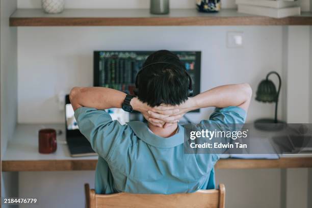 asian chinese man hands behind back looking at computer monitor video call at home - hands behind head stock pictures, royalty-free photos & images