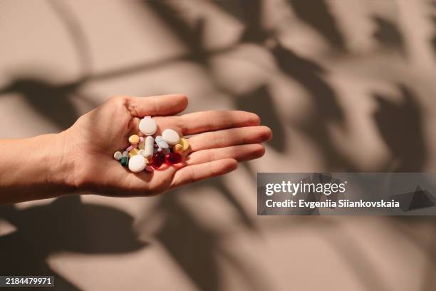 woman's hand holding colorful pills. - complemento vitamínico fotografías e imágenes de stock