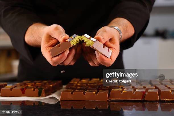 un chef masculin montre son nouveau chocolat de dubaï - chocolat photos et images de collection