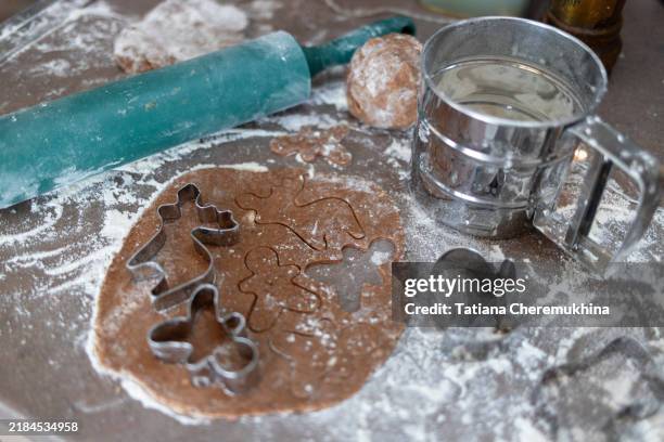 gingerbread cookies dough with cookie cutters and rolling pin. christmas baking concept. - figurita de jengibre fotografías e imágenes de stock