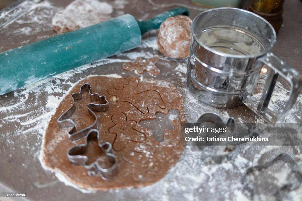 Gingerbread cookies dough with cookie cutters and rolling pin. Christmas baking concept.