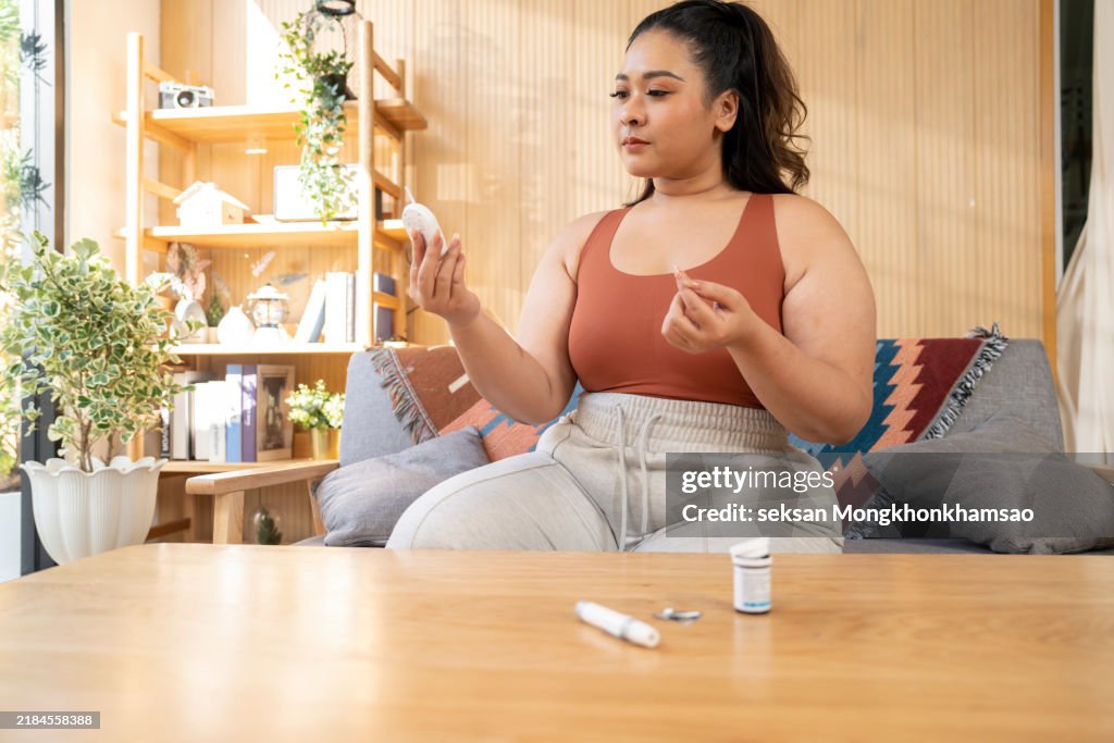 Young woman checking glucose level at home