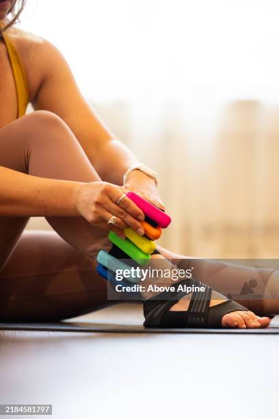 caucasian woman putting on ankle weights - ankle weights stock pictures, royalty-free photos & images
