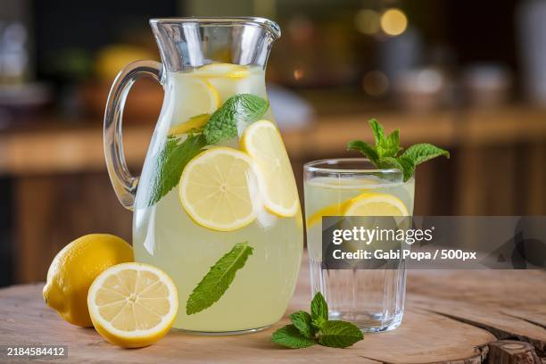 a glass carafe filled with refreshing lemonade - citroen frisdrank stockfoto's en -beelden