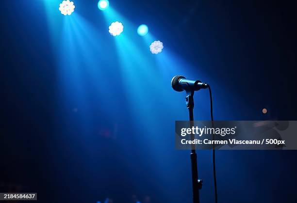 theatre show with colored spotlights and microphone - bühnenscheinwerfer stock-fotos und bilder