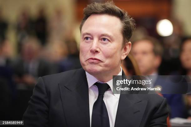 Elon Musk listens as U.S. President-elect Donald Trump addresses a House Republicans Conference meeting at the Hyatt Regency on Capitol Hill on...