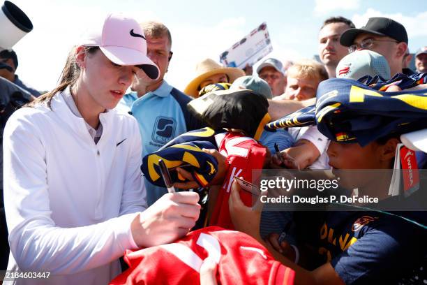 Professional basketball player Caitlin Clark signs autographs for fans on the 18th green as Annika Sorenstam looks on prior to The ANNIKA driven by...