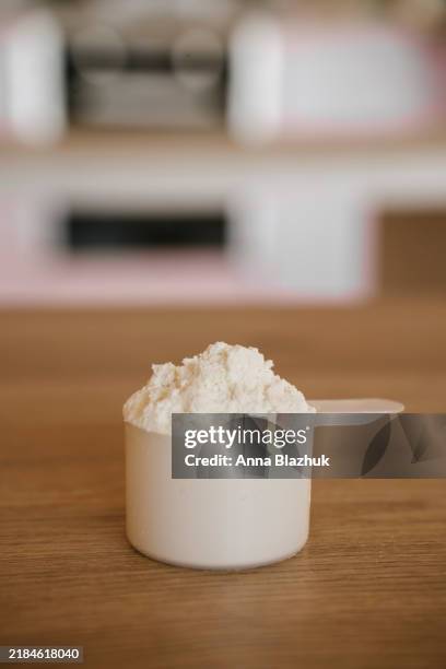 measuring scoop of collagen powder on the kitchen counter at home close-up - collagene foto e immagini stock