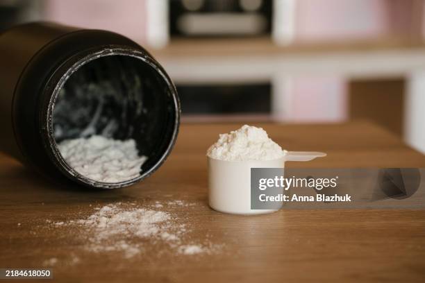 measuring scoop of collagen powder on the kitchen counter at home close-up - proteïnedrank stockfoto's en -beelden