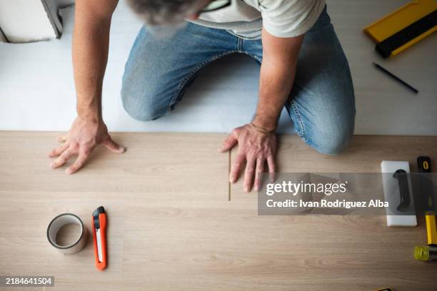 menuisier installant un nouveau parquet stratifié ou parquet dans une maison - parquet flottant photos et images de collection