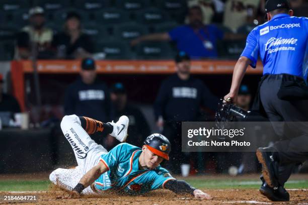 Jose Cardona of Naranjeros de Hermosillo dives to score a run in the third inning against Sultanes de Monterrey during a Liga ARCO Mexicana del...