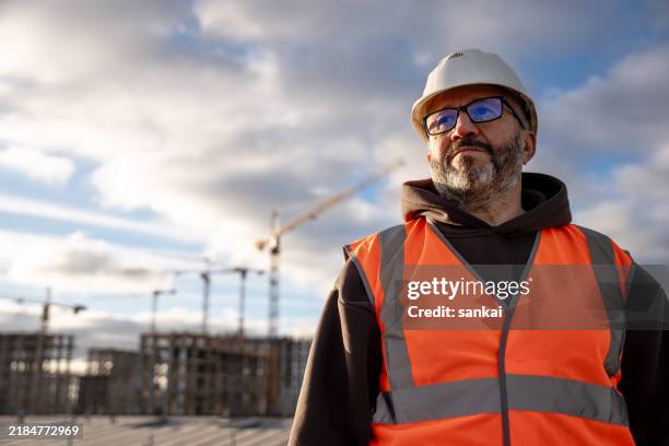 construction worker wearing safety gear at building site - mestre de obras imagens e fotografias de stock