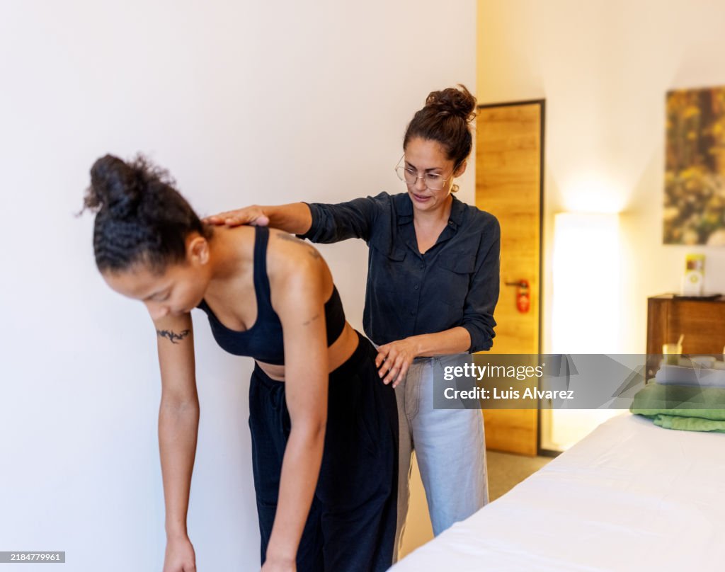 Therapist Correcting Client's Back Alignment