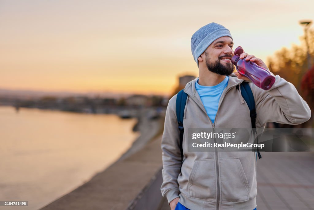 Refresco matinal à beira do rio com um homem bebendo água
