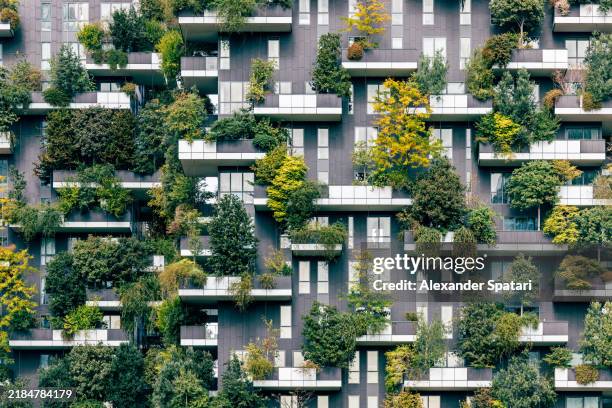 green plants and trees growing on bosco verticale residential apartment building balconies, milan, italy - milan stock pictures, royalty-free photos & images