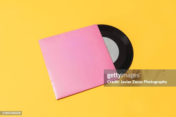 vinyl record isolated on yellow background - schallplatte stock-fotos und bilder