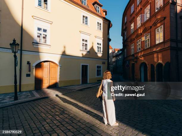 mujer explorando el distrito histórico de mala strana en praga durante el amanecer república checa - praga fotografías e imágenes de stock